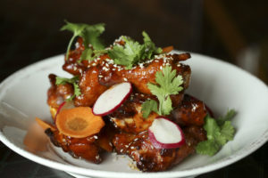Smoked Springer Mountain chicken wings with gochujang pepper jelly, pickled carrots and sesame seeds.