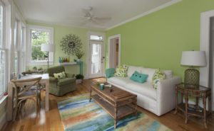 The sun room’s yellow-green walls were inspired by a pair of pillows that Winburn had made from some old IKEA fabric (pictured on sofa and armchair).