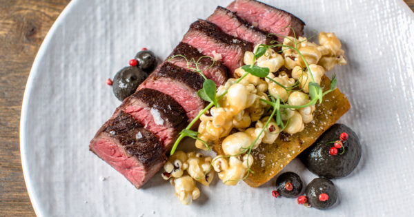Griddled beef coulotte is served with a potato hash brown, garlic confit, huitlacoche and porcini caramel corn.