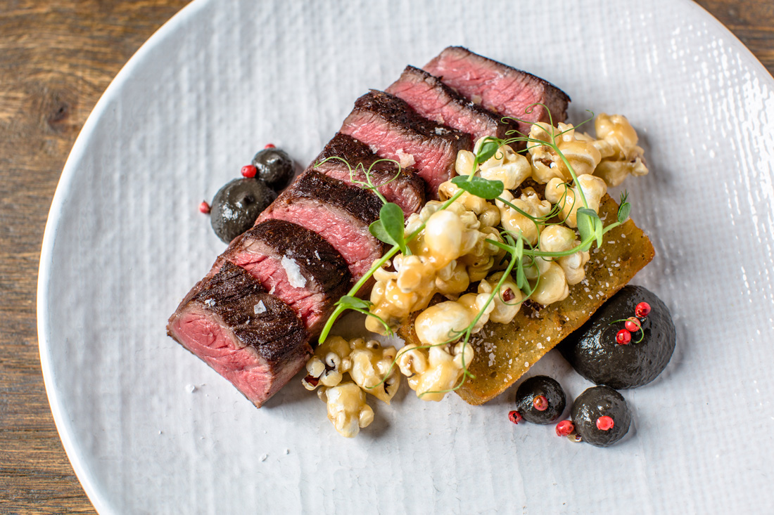 Griddled beef coulotte is served with a potato hash brown, garlic confit, huitlacoche and porcini caramel corn.